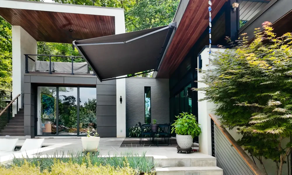 KE Domina motorized retractable awning extended over outdoor dining area, luxury modern home Gainesville GA